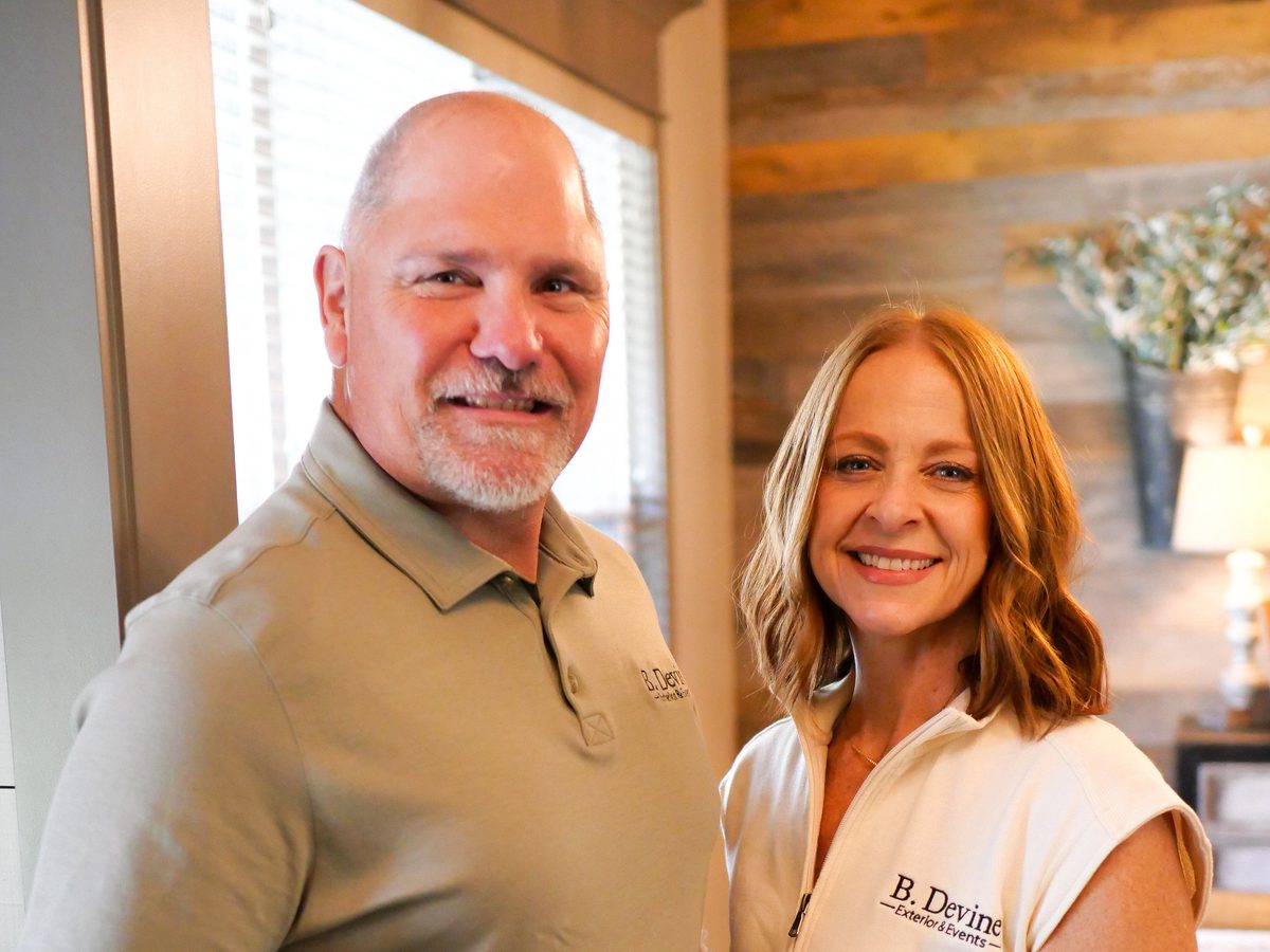 Brett and Shannon Devine, the owners of B. Devine Exterior and Events, in branded shirts
