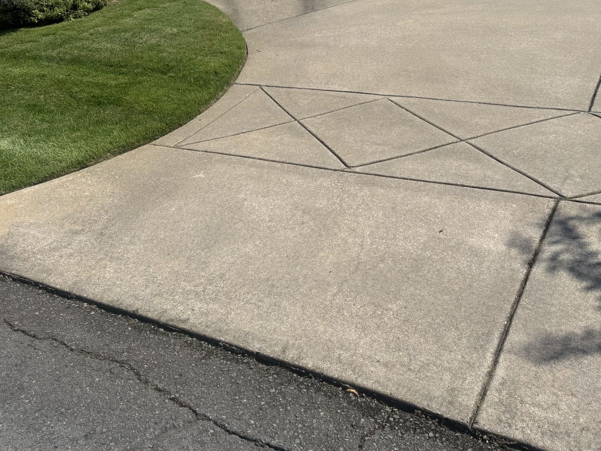A concrete driveway apron that has greyed and stained with age