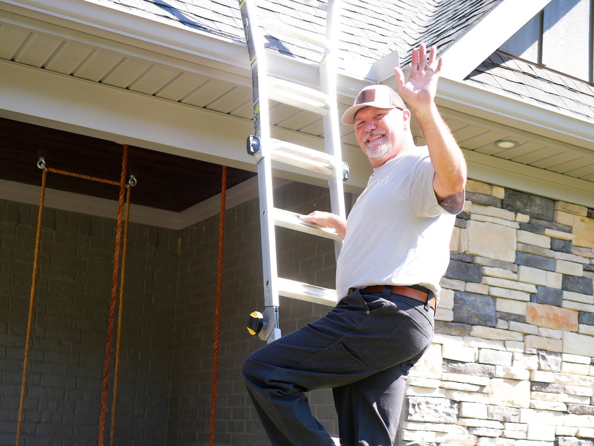 Brett Devine on a ladder at a home he is scheduled to service